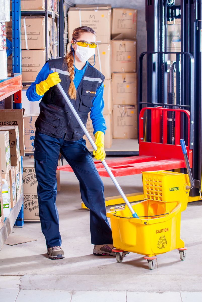 Cleaner mopping the floor of a large commercial space